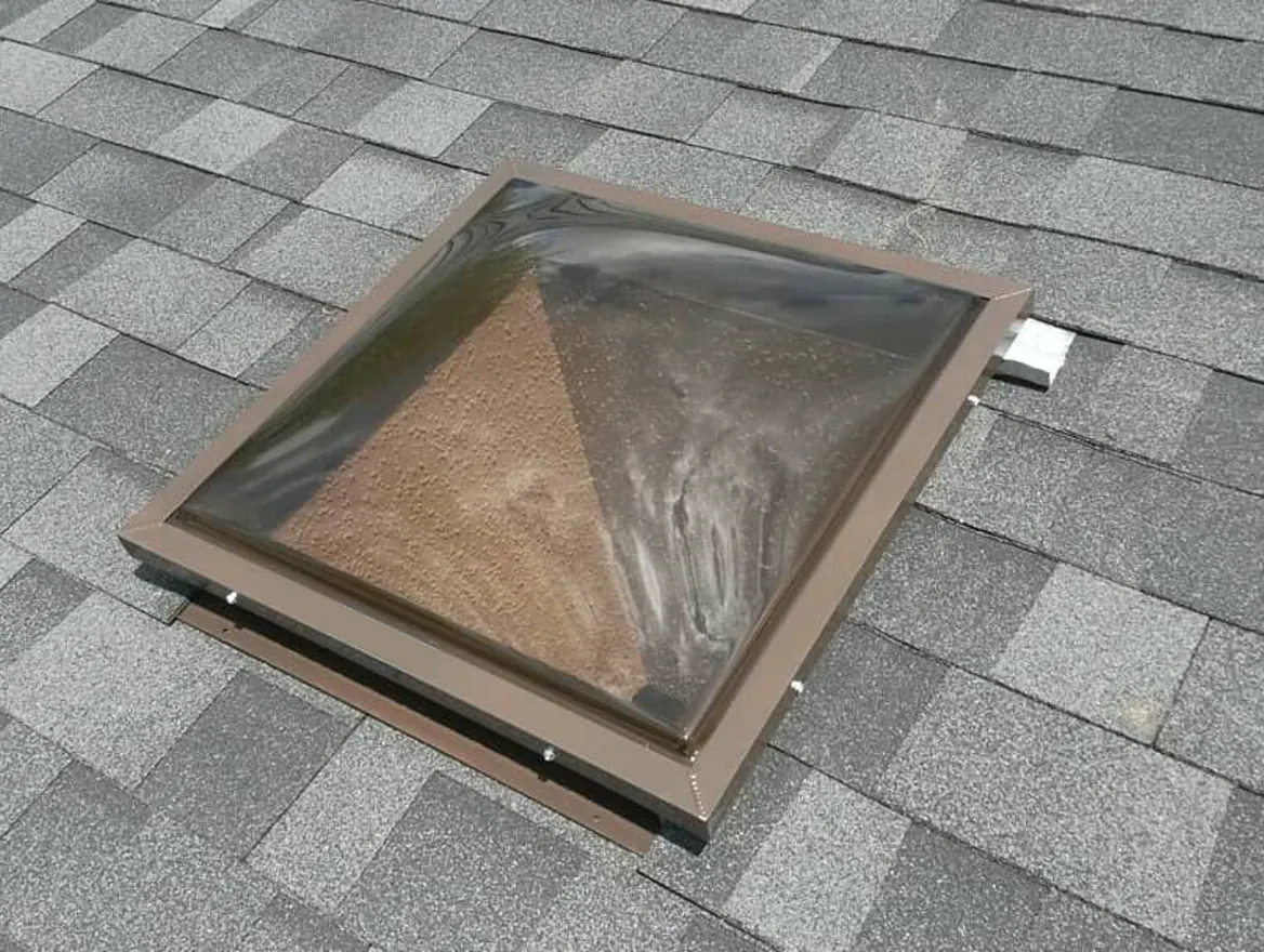 A skylight set into a gray shingle roof